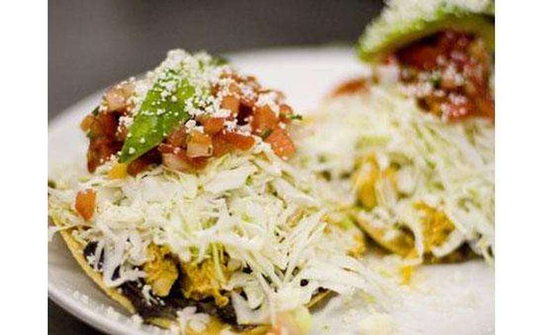 tacos with slaw, tomatoes, and a lime wedge