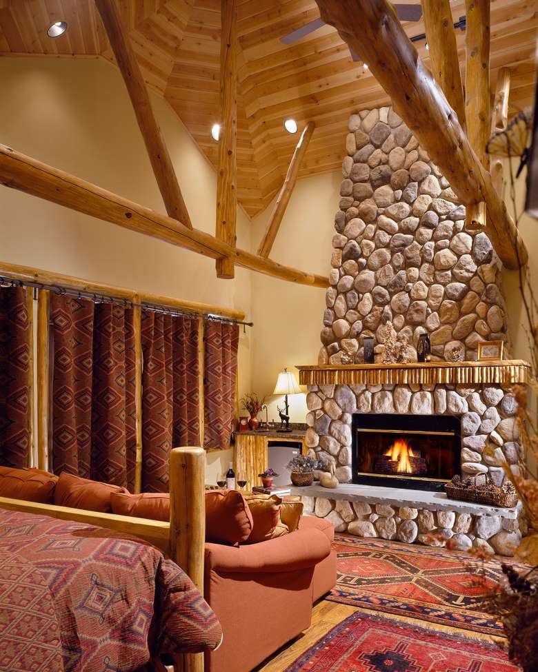 the living room with high ceilings and a fire in the fireplace