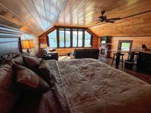 bedroom and living area with large window, lake views