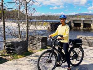 lady on a bike in front of water