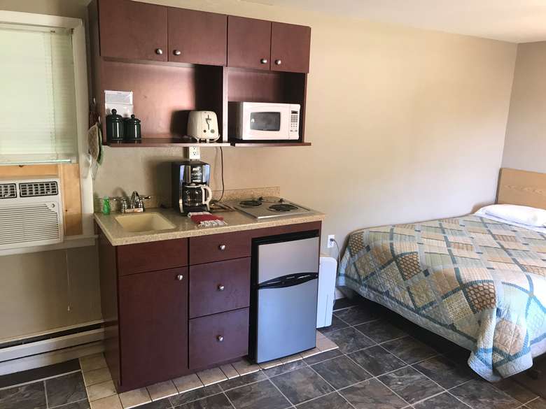room with bed, mini fridge, microwave, sink