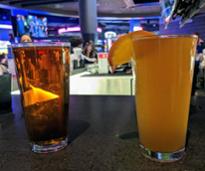 two glasses of beers on counter at bar
