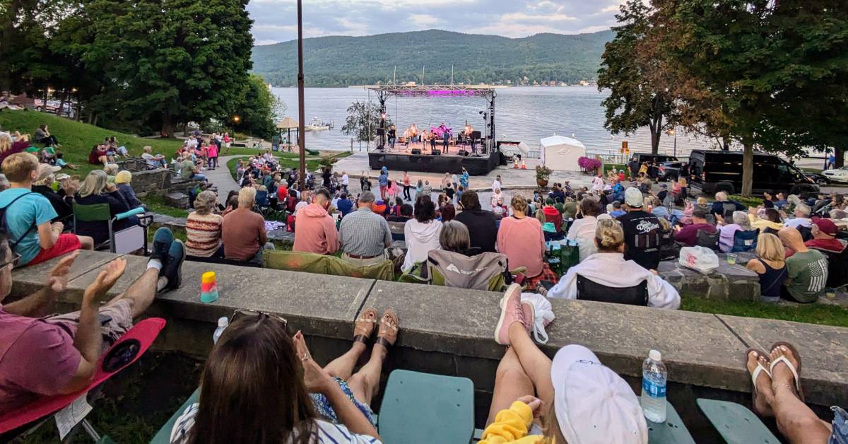 people watching outdoor concert by lake george